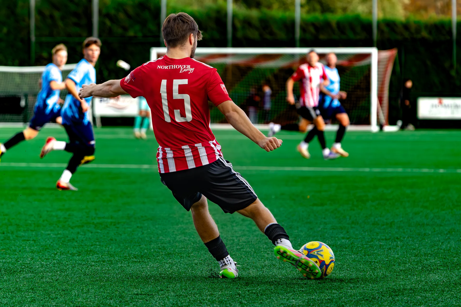 Shaftesbury FC player striking the ball at Shaftesbury Town Stadium